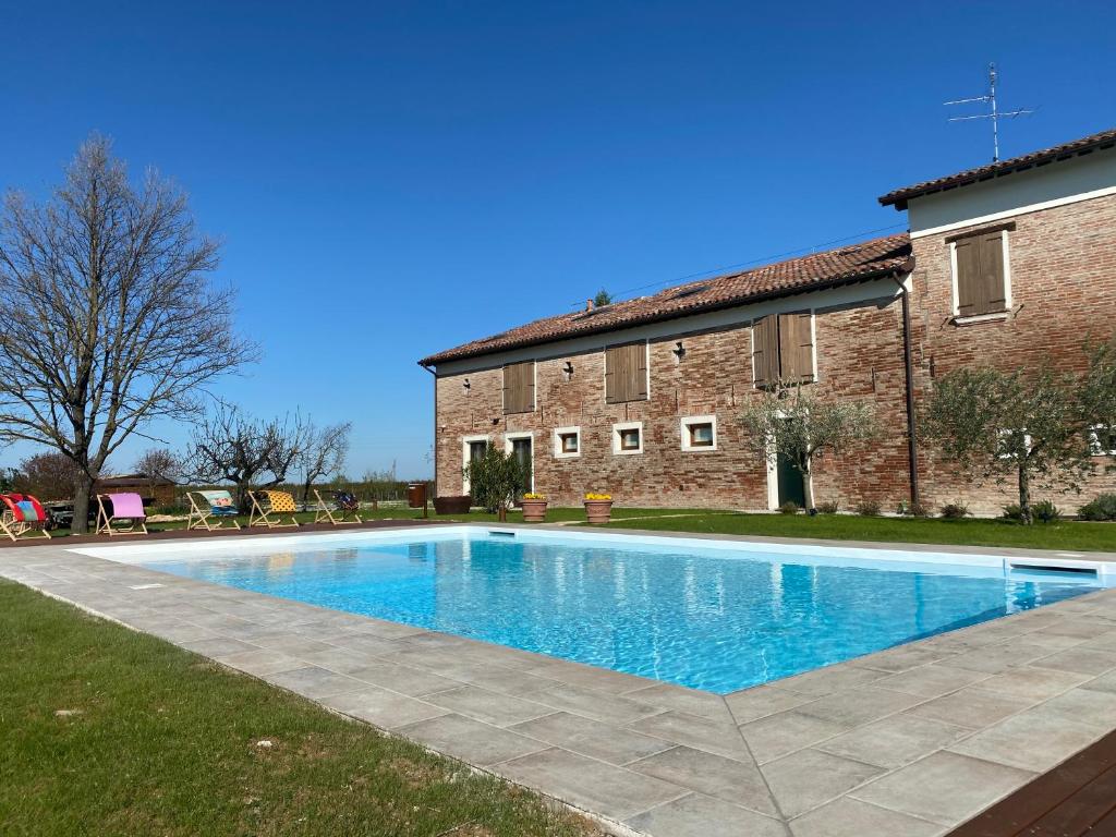 - une piscine en face d'un bâtiment en briques dans l'établissement Podere Selvatici, à Imola