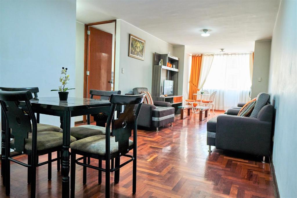 sala de estar con mesa, sillas y sofá en Eral Apartments Santa Catalina, en Lima