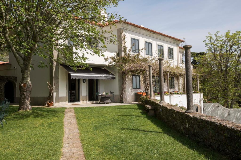 uma casa com um jardim de relva em frente em Quinta da Paciencia em Sintra