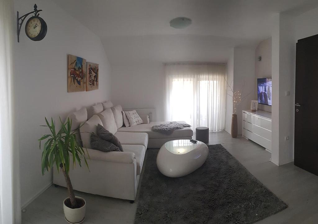 a living room with a white couch and a table at Apartman Hamad, Bihać in Bihać