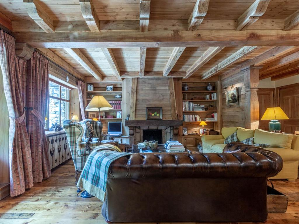 un salon avec un canapé en cuir et une cheminée dans l'établissement Charmant Duplex Montagnard, 4 Pièces + Alcôve, Proche des Pistes à Val-d'Isère - FR-1-694-97, à Val dʼIsère