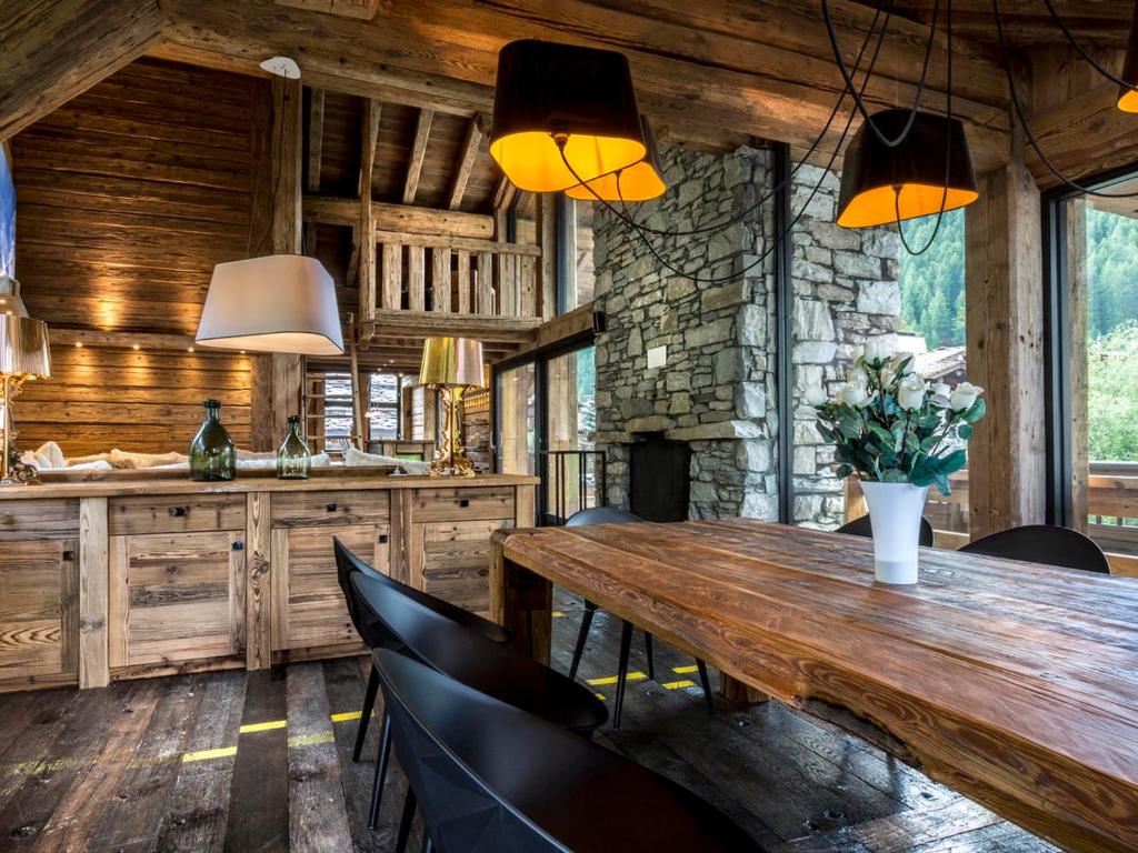 ヴァル・ディゼールにあるChalet de luxe avec piscine et hammam à Val-d'Isère, 10 personnes à proximité du centre-ville - FR-1-694-95の木製のテーブルと椅子のあるダイニングルーム