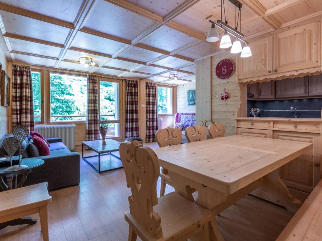 une cuisine et une salle à manger avec une table et des chaises en bois dans l'établissement Appartement spacieux avec wifi, balcon Sud, parking, proche pistes - Val d'Isère - FR-1-694-112, à Val dʼIsère