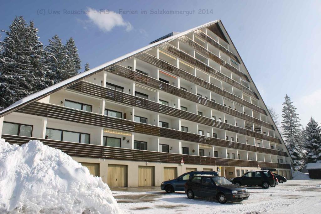 a large building with cars parked in the snow at Apartments in Bad Mitterndorf - Steiermark 41117 in Bad Mitterndorf
