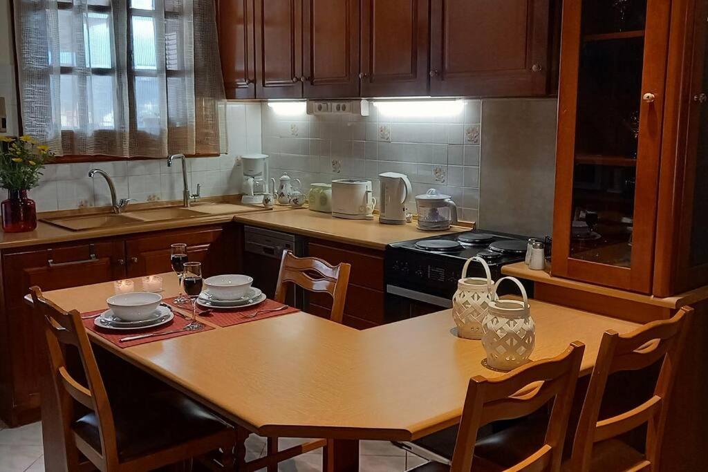 a kitchen with a wooden table with chairs and a stove at Giannis Traditional House in Vamos