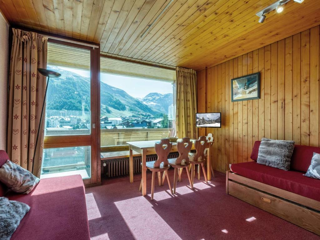 un salon avec une table et des chaises et une fenêtre dans l'établissement Studio de 25m² au 6ème étage, proche centre, balcon, Wifi, animaux acceptés - FR-1-694-264, à Val dʼIsère