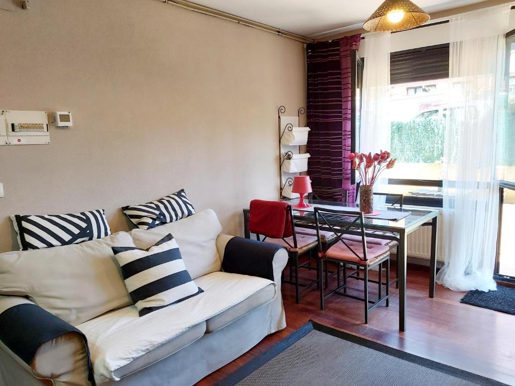 salon z kanapą i stołem w obiekcie CASTRO COSTA NORTE Apartamento Jardín Garaje w mieście Castro-Urdiales