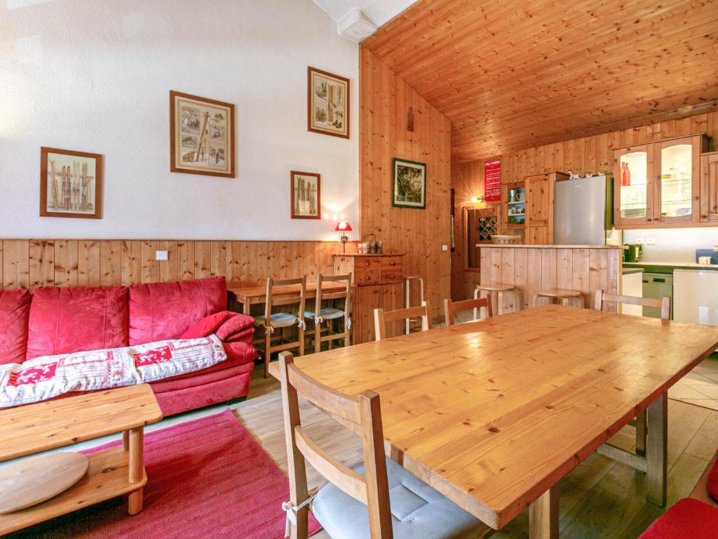 a living room with a red couch and a wooden table at Spacieux appartement 9 pers. à Val-d'Isère, skis aux pieds, Wi-Fi, proche commodités - FR-1-694-306 in Val dʼIsère