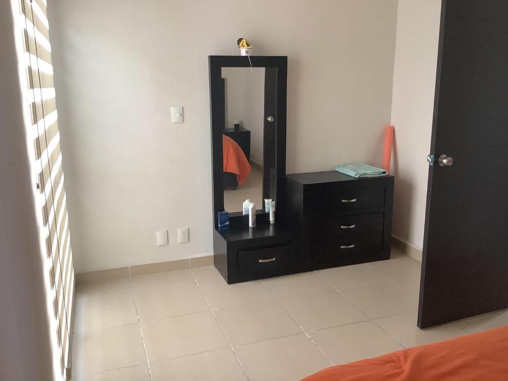 een slaapkamer met een zwarte dressoir en een spiegel bij Casa Meneses in Sanctórum