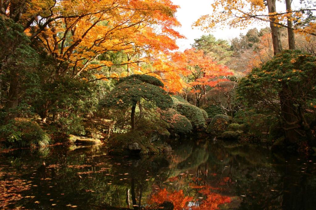 a painting of a pond in a garden with trees at Senkyoro in Hakone