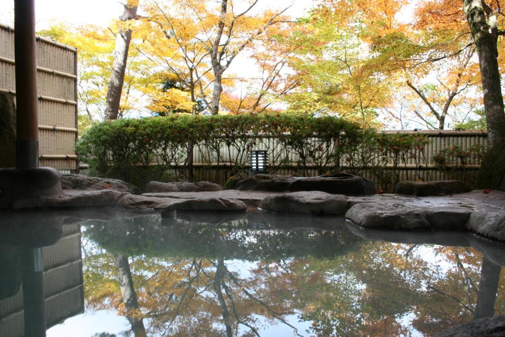 a pool of water in a yard with trees at Senkyoro in Hakone