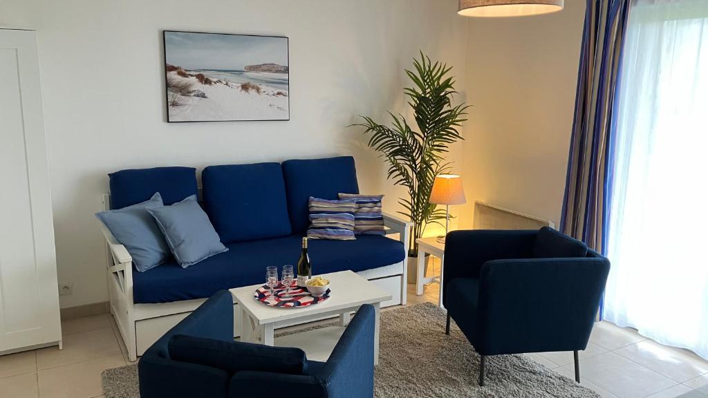 a living room with a blue couch and two chairs at F50 Ferme de Deauville 1 CH rez-de-jardin avec escalier in Saint-Arnoult