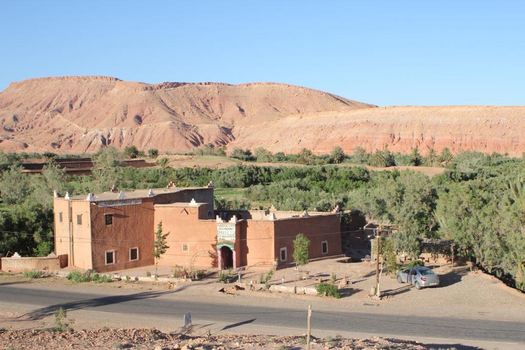 a building in the desert with a mountain in the background at auberge restau tombouctou in Aït Benhaddou