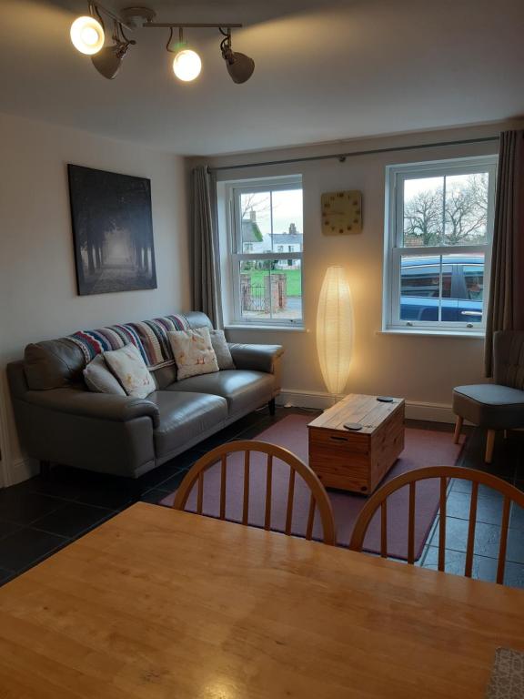 a living room with a couch and a table at The Cosy West Wing, dog friendly in Martham