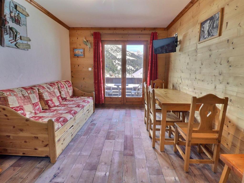 - un salon avec un canapé et une table à manger dans l'établissement Charmant 2 pièces skis aux pieds avec balcon, idéalement situé aux Allues - FR-1-182-48, à Méribel