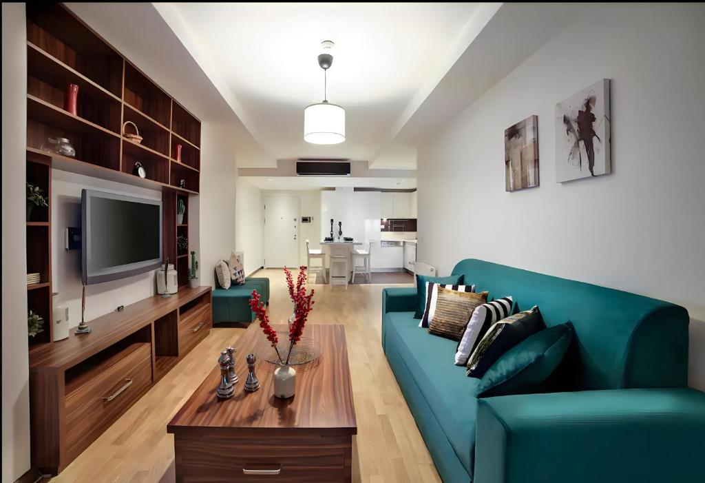 ein Wohnzimmer mit einem blauen Sofa und einem TV in der Unterkunft Luxury Residence in Şişli (Pool/Garage/Gym) in Istanbul