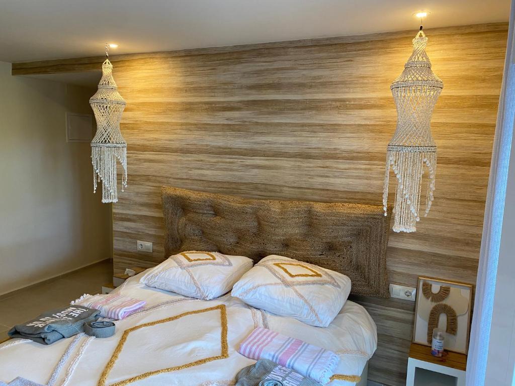 a bedroom with a bed with a wooden wall at Casa El Sueño in Jávea