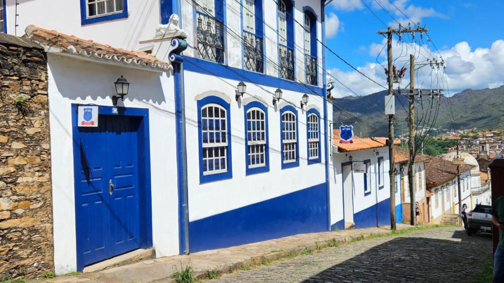 um edifício azul e branco com uma porta azul em A3EM Casa de Gorceix em Ouro Preto