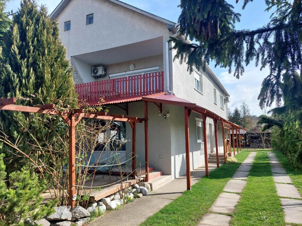 ein Haus mit einem roten Balkon an der Seite in der Unterkunft Oázis Vendégház és Appartman in Szilvásvárad