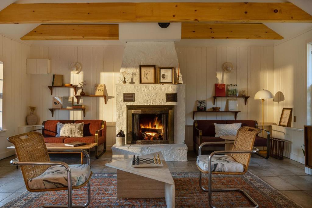 a living room with a fireplace and a table and chairs at Eastwind Hotel Lake Placid in Lake Placid