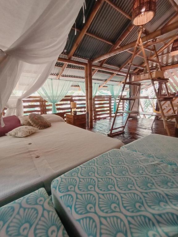 a bedroom with two beds and a ladder at La Casa en el Aire in Palomino