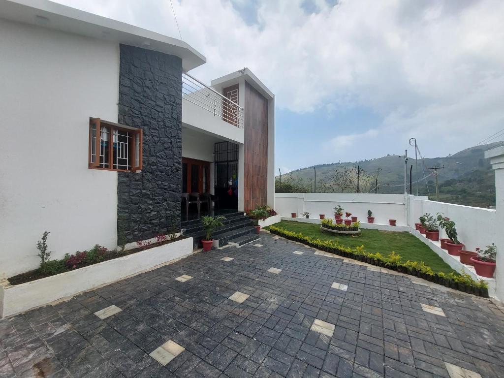 a house with a stone walkway in front of it at Kodai Diva Inn - Home Stay in Kodaikānāl