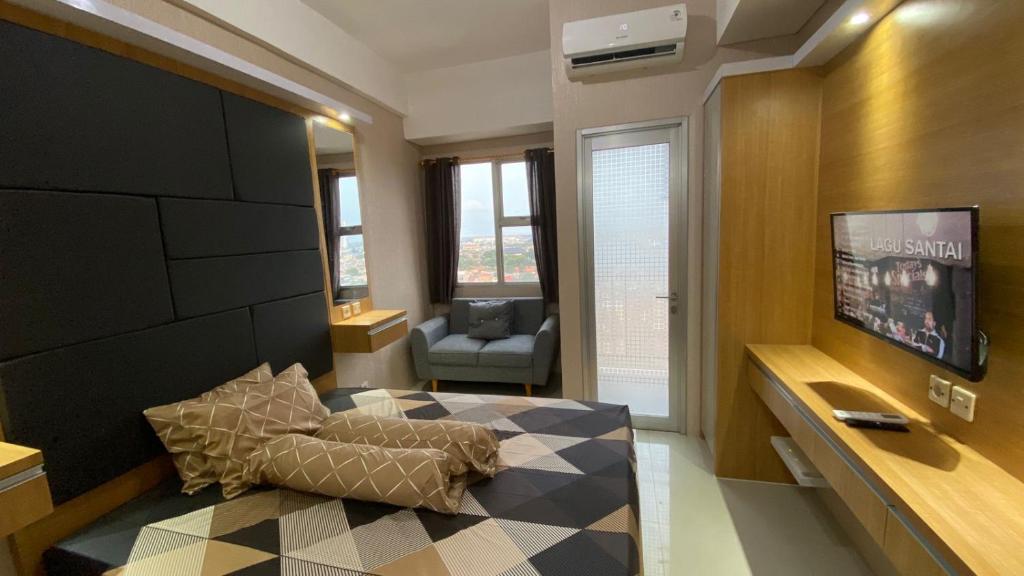 een woonkamer met een bed en een televisie bij Rifky Room Studio Transpark in Bulanbulan