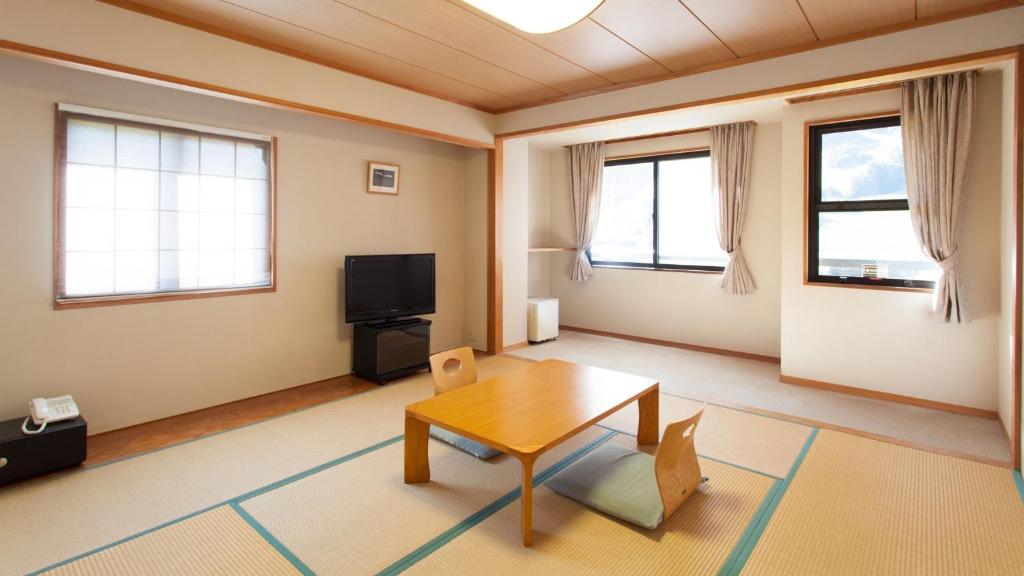 uma sala de estar com uma mesa e uma televisão em Villa Schole Hakuba - Vacation STAY 19519v em Yotsuya