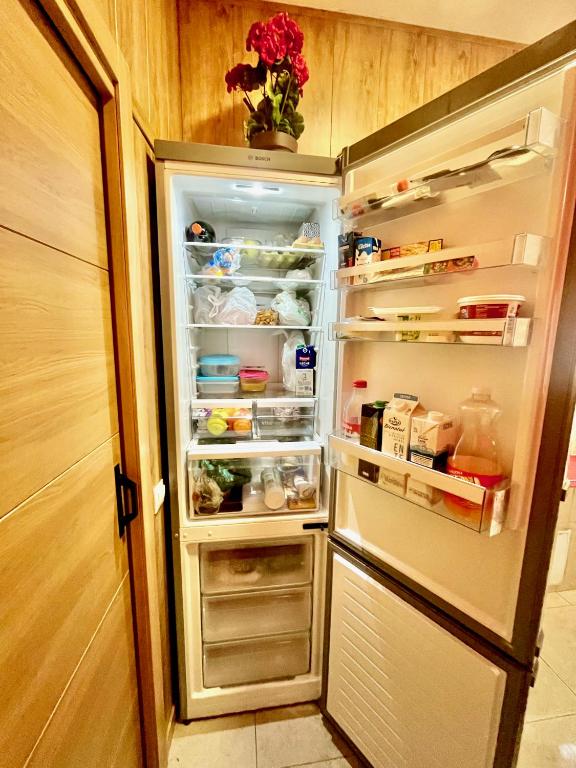 - un réfrigérateur avec une porte ouverte avec de la nourriture à l'intérieur dans l'établissement Hostel Vida Verde, à Madrid
