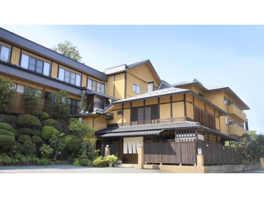 un grande edificio giallo con una recinzione di fronte ad esso di Saikatei Jidaiya - Vacation STAY 96286v a Kaminoyama