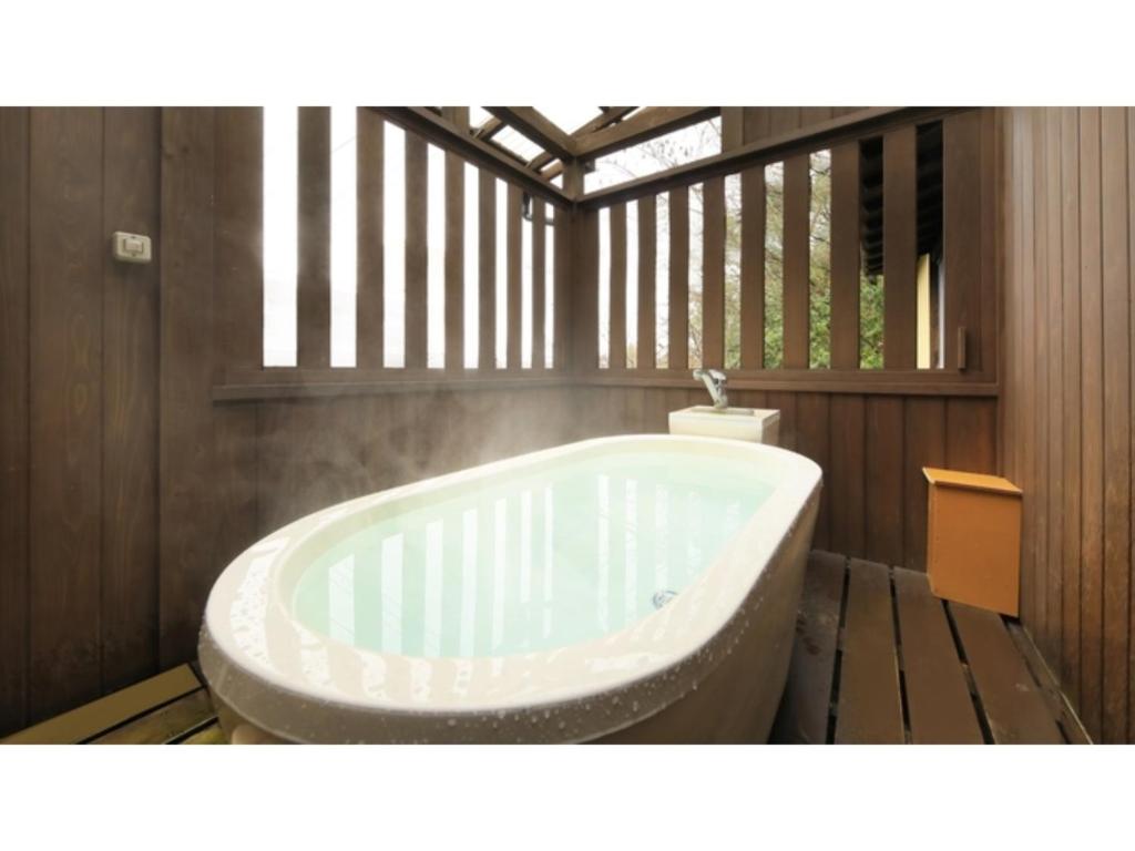 uma banheira na casa de banho com uma janela em Saikatei Jidaiya - Vacation STAY 96432v em Kaminoyama