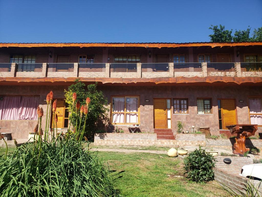 stary budynek z żółtymi drzwiami i dziedzińcem w obiekcie Ohana Apartments (solo familias) w mieście Villa Carlos Paz