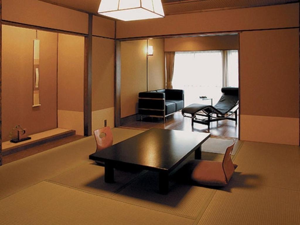 Saikatei Jidaiya - Vacation STAY 96439v في Kaminoyama: غرفة معيشة مع طاولة وكراسي