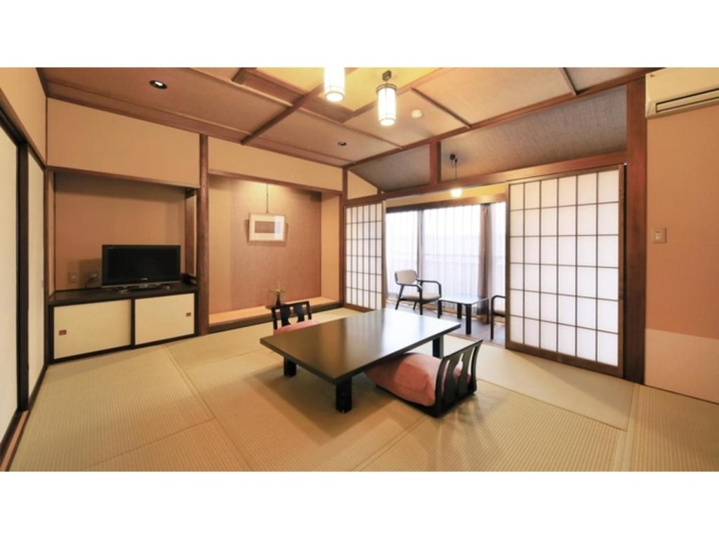 een woonkamer met een tafel en een televisie bij Saikatei Jidaiya - Vacation STAY 96425v in Kaminoyama