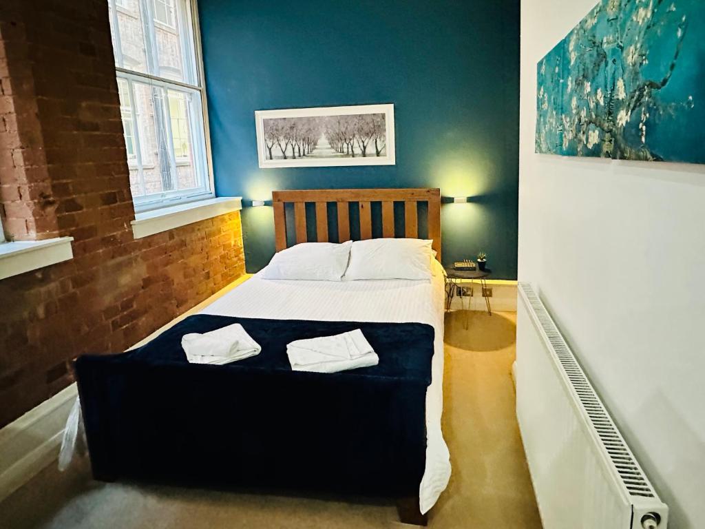 ein Schlafzimmer mit einem Bett mit zwei Handtüchern darauf in der Unterkunft Lovely Studio Apartment in the Heart of Nottingham in Nottingham