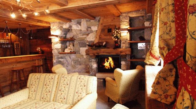 a living room with a couch and a fireplace at Hotel Tersiva in Valtournenche