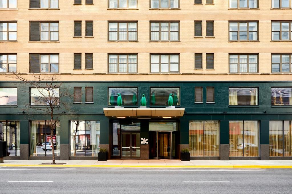 un gran edificio de ladrillo con asientos verdes delante de él en 21c Museum Hotel Chicago, en Chicago
