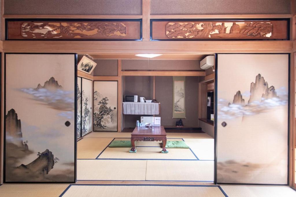 een kamer met twee deuren met een tafel in het midden bij Nosecho Guest House - Vacation STAY 14366 in Kawabe