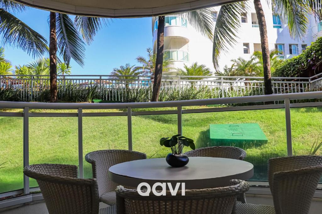 d'un balcon avec une table et des chaises et une vue sur la cour. dans l'établissement Qavi - Apto em Resort Beira Mar Cotovelo #InMare43, à Parnamirim