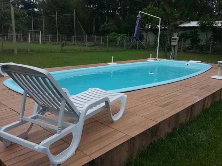 una sedia accanto alla piscina di Casa com piscina e salão de jogos para aluguel de temporada e finais de semana em Torres/RS. a Torres