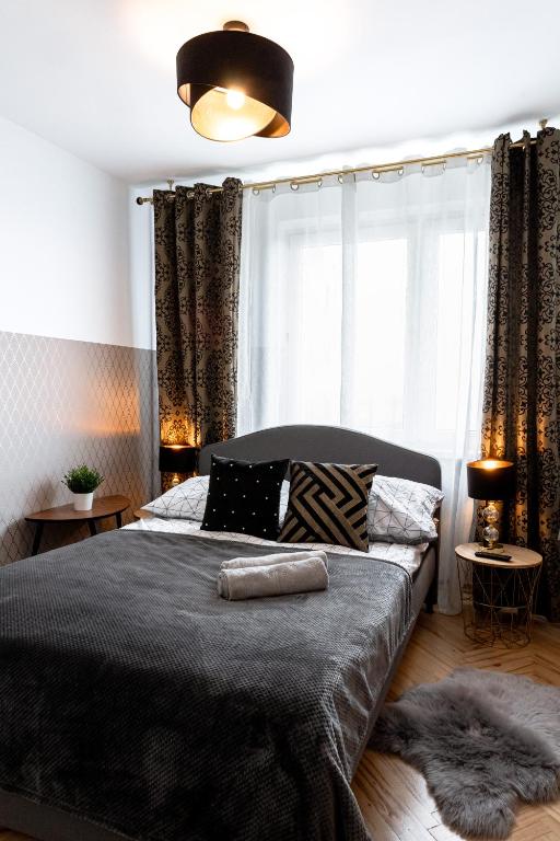 a bedroom with a bed and a large window at ClickTheFlat Conrada Apart Rooms in Warsaw