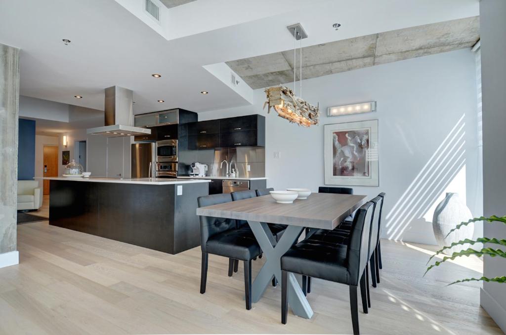 a kitchen and dining room with a table and chairs at Les Immeubles Charlevoix - Le 760608 in Quebec City