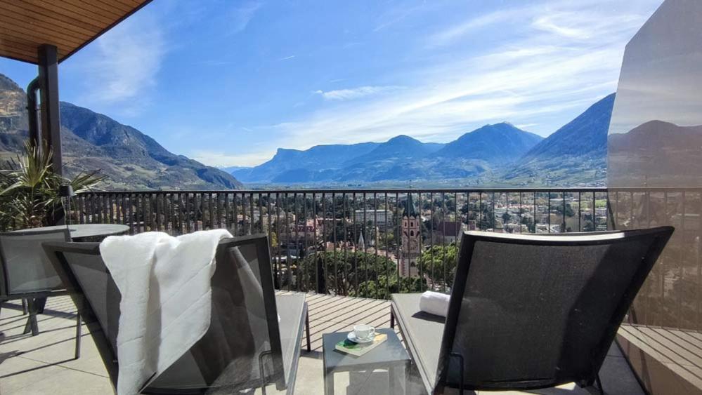 a balcony with chairs and a view of a city at LA LIBELLA - slow living Suites in Merano