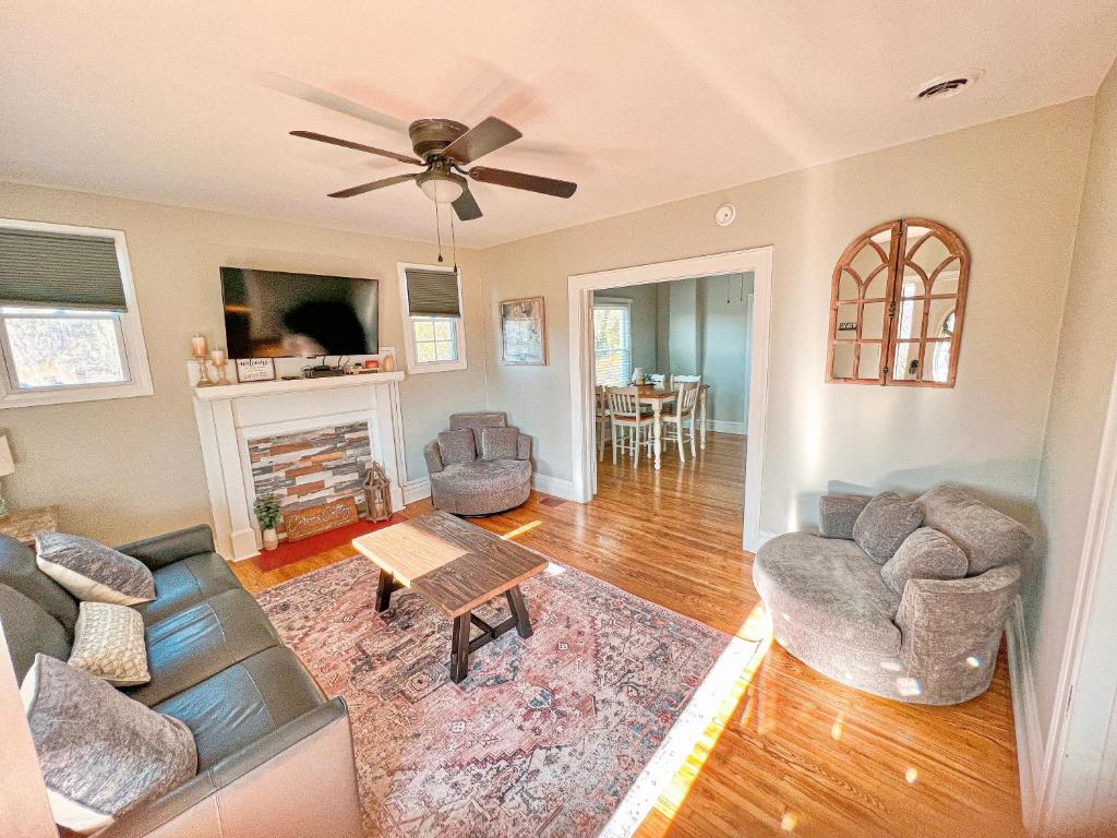 a living room with a couch and chairs and a fireplace at Cozy and Renovated 3 Bedroom Home 
