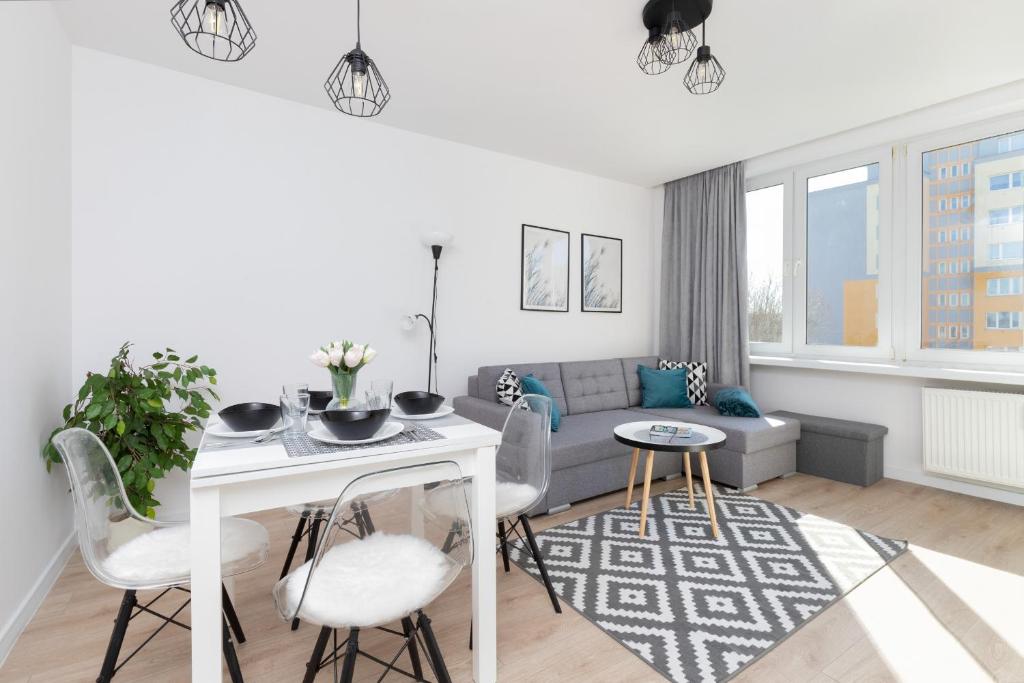 ein Wohnzimmer mit einem Sofa und einem Tisch in der Unterkunft Family apartment with balcony Warszawska Gdynia by Renters in Gdynia