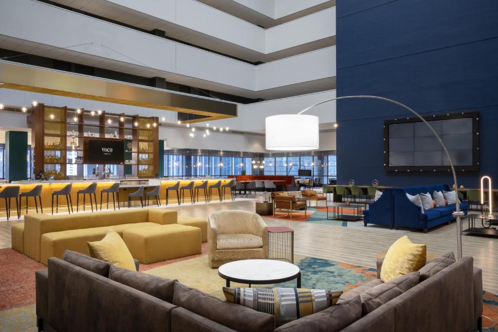 a lobby with couches and chairs and a bar at voco Chicago Downtown, an IHG Hotel in Chicago