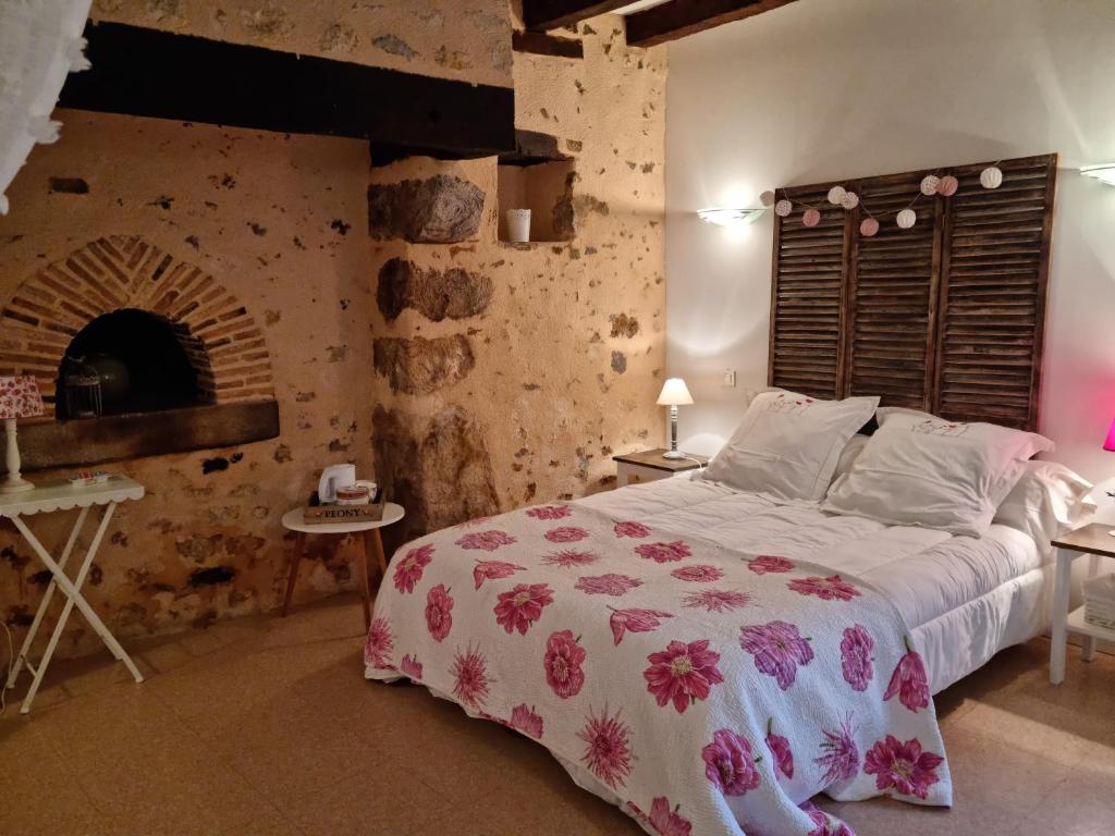 a bedroom with a bed and a brick wall at L &#39;Aupinouse Chambre double Pivoine avec salle d&#39;eau privative in La Suze-sur-Sarthe