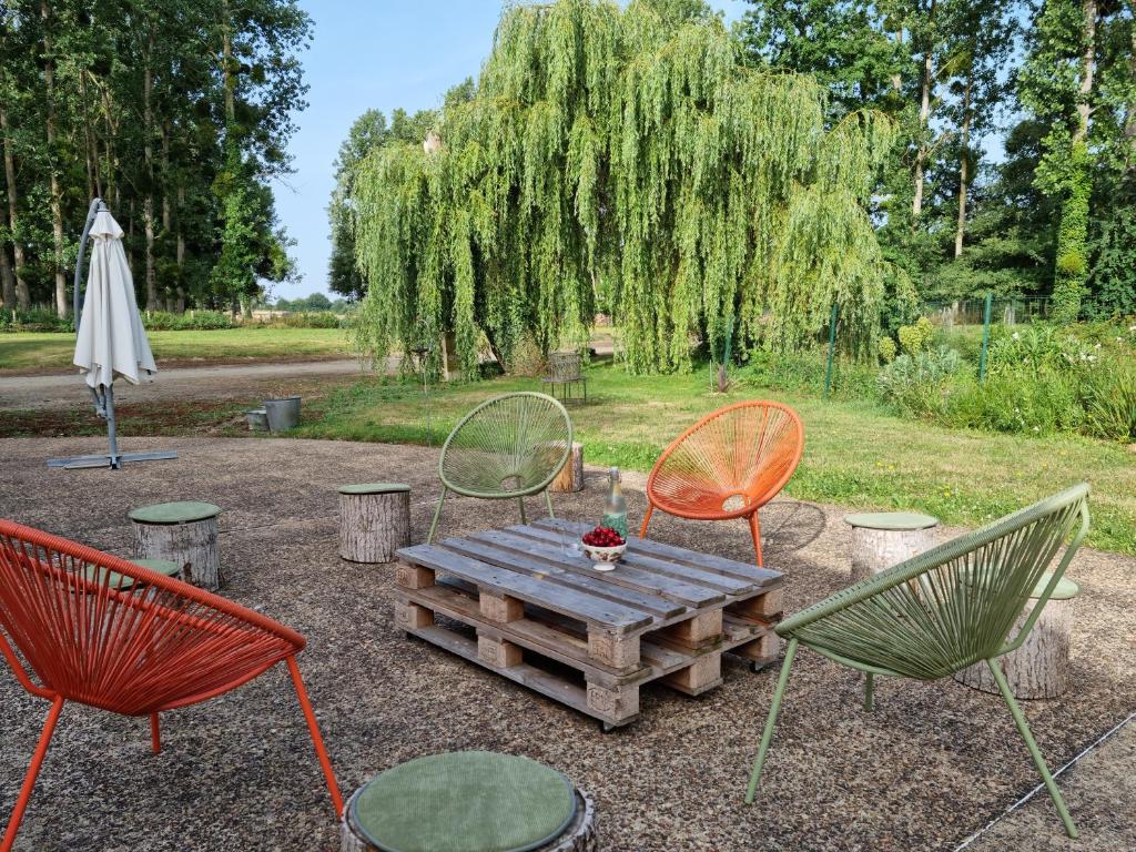 three chairs and a wooden table with a picnic at L &#39;Aupinouse Chambre double Pivoine avec salle d&#39;eau privative in La Suze-sur-Sarthe