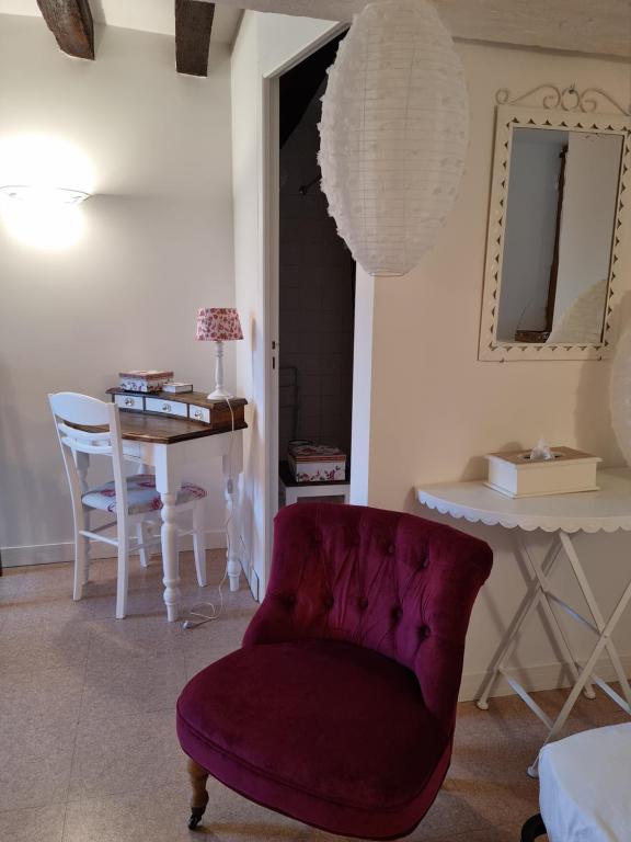 a living room with a chair and a table at L &#39;Aupinouse Chambre double Pivoine avec salle d&#39;eau privative in La Suze-sur-Sarthe