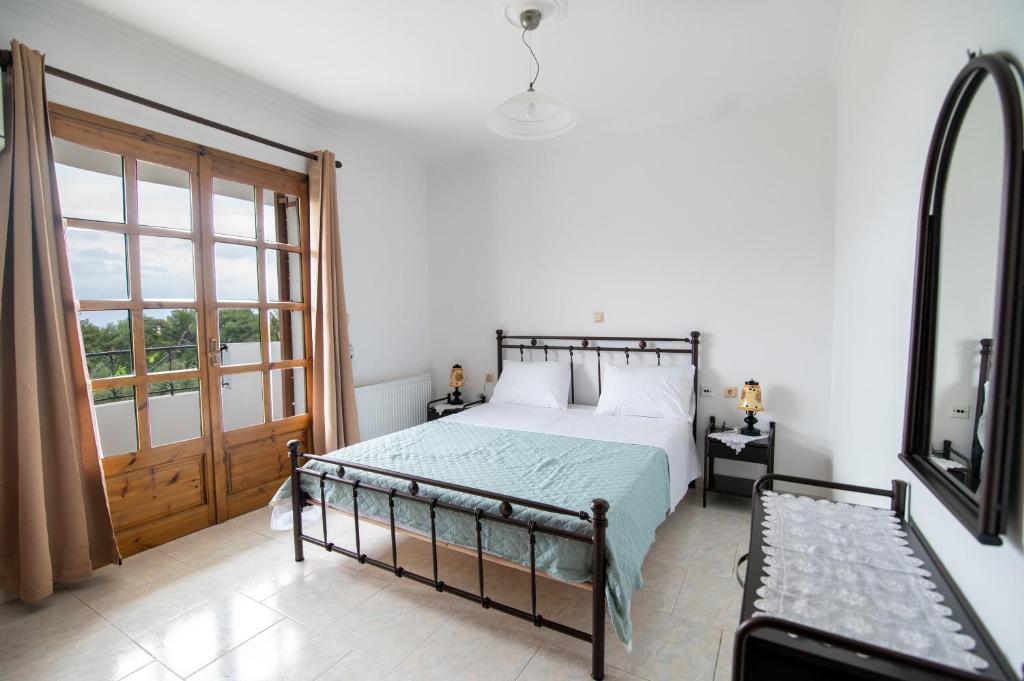 1 dormitorio con cama y ventana grande en Uliveto 3bd Rustic House, en Kardamaina